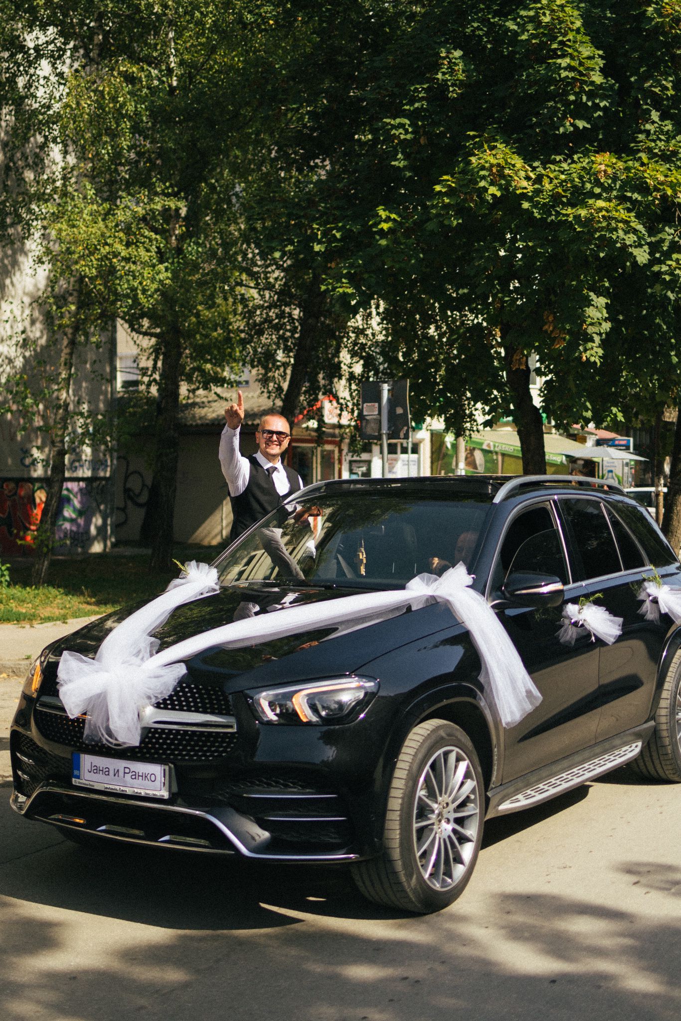 dekoracija auta za svadbu covek sedi na automobilu